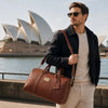 Man with sunglasses carrying a Leather Duffle Bag Small near Sydney Opera House.