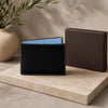 Premium Designer Mens Leather Wallet in black with blue interior, displayed next to elegant packaging.