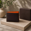 Premium Designer Mens Leather Wallet with orange interior and stitching on a stone surface.