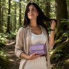 Crossbody Phone Wallet for Women in lilac color held by a woman in a forest setting, showcasing elegance and style.