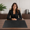 Woman in a black suit sitting at a desk with the Leather Desk Pad.