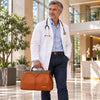 Male doctor in a white coat carrying a Doctors Bag in a modern setting.