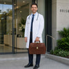 Doctor standing outside with Elite Doctors Bag, wearing a white coat and stethoscope, showcasing sophistication and style.