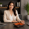 A woman presenting the Leather Desk Tray on a stylish office desk with a laptop.