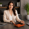 Woman showcasing the Leather Desk Tray on a modern office desk with a laptop in the background.