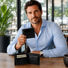 A man in a blue shirt holding a Mens Leather Wallet, showcasing its compartments and sleek design.