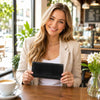 Model holding an Exclusive Womens Leather Wallet in a cozy café setting with coffee.