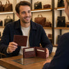 Man inspecting Mens Bifold Wallet With ID Window in a store, showcasing its features and premium Italian leather.