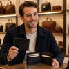 Smiling man holding Mens Bifold Wallet With ID Window, showcasing interior card slots and ID window.