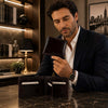 Man examining Mens Leather Wallet Bifold made from premium Italian leather, showcasing its card slots and compartments.