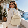 Model wearing Genuine Leather Backpack overlooking scenic coastal view, showcasing premium design and functionality.