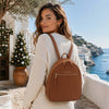 Woman wearing Genuine Leather Backpack in a beautiful coastal setting with festive decor.