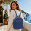 Woman wearing a blue Genuine Leather Backpack against a scenic coastal backdrop.