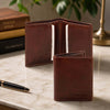 Genuine Leather Wallet open showing card slots on a marble table with a pen and books in the background.