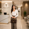 Woman holding a Monalisa Doctors Bag in a modern medical office setting with elegant décor.