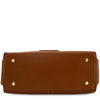 An underneath view of the Cognac pebbled Italian leather duffle bag shown from the bottom front view, featuring four gold-tone metal studs on the corners