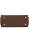 An underneath view of the Dark Taupe pebbled Italian leather duffle bag shown from the bottom front view, featuring four gold-tone metal studs on the corners
