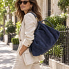 Woman In The Street Carrying The Dark Blue Italian Suede Drawstring Shoulder Bag Over Her Shoulder