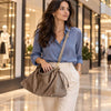 Woman In A Shopping Centre Carrying The Dark Taupe Italian Suede Drawstring Shoulder Bag As A Crossbody Bag