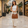 Woman wearing cream outfit carrying the Italian Leather Bag in a stylish shopping mall.