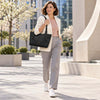 A woman in a stylish outfit walking outdoors with a Italian Leather Tote Bag.