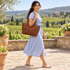 Model carrying a Italian Leather Tote Bag in style, surrounded by vineyards and greenery.