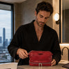 Man in a black robe using the Mens Toiletry Bag Leather in a modern bathroom.