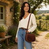 Ladies Leather Bag worn by a woman outdoors, showcasing its elegant design and practicality in a scenic setting.