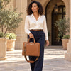Elegant woman carrying a Ladies Leather Business Bag with two handles and a detachable strap, suited for professionals.