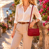 Leather Clutch Bag for Women in a stylish outdoor setting with a sunset backdrop and blooming flowers.