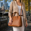 Ladies Leather Handbag carried by a woman in a city setting, showcasing its stylish design and versatility.