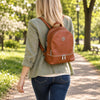 Woman Walking In The Park With  The Cognac Ladies Small Leather Backpack
