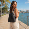 Woman wearing a stylish Leather Backpack For Women while walking by the waterfront.