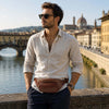 Man wearing a Leather Bum Bag with Florence in the background, showcasing style and functionality.