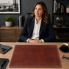 Woman sitting at desk with a Leather Desk Pad, showcasing its luxurious surface for writing.