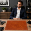 Leather Desk Pad on an elegant office desk with a professional man seated, showcasing a stylish work environment.