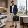 Man in business attire holding a Leather Doctor Bag in a modern office setting, showcasing style and professionalism.
