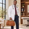 Smiling male doctor in a white coat holding a Italian Leather Doctors Bag in a modern medical office.