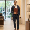 Man in suit holding the Leather Document Case With Handle in a modern retail setting.