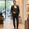 Man in suit holding the dark brown Leather Document Case With Handle in a modern retail setting.