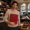 Man holding a red Leather Document Case With Ring Binder in a stylish store setting.