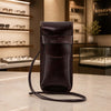 Leather Eyeglasses Case displayed on a counter, showcasing its sleek design and detachable shoulder strap.