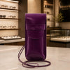 Leather Eyeglasses Case in purple with detachable shoulder strap displayed on a marble countertop.