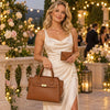 Elegant woman holding a leather handbag and wallet set in a floral setting, showcasing Leather craftsmanship.