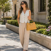 Woman in a stylish outfit holding a Leather Handbag For Women while walking outdoors.