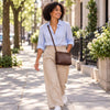 Woman walking in the street with the chocolate Leather Ladies Handbag in pebbled leather with a leather green shoulder strap 