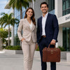 Professional couple posing outdoors with the Leather Laptop Briefcase Bag, dressed in business attire.