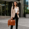 Stylish woman in a beige blazer holding Leather Business Laptop Bag, perfect for professionals.