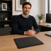 Man sitting at a desk with a Leather Mouse Pad, promoting elegance and functionality for workspaces.
