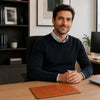 Leather Mouse Pad on a desk with a smiling man in a navy sweater, showcasing premium office accessories.